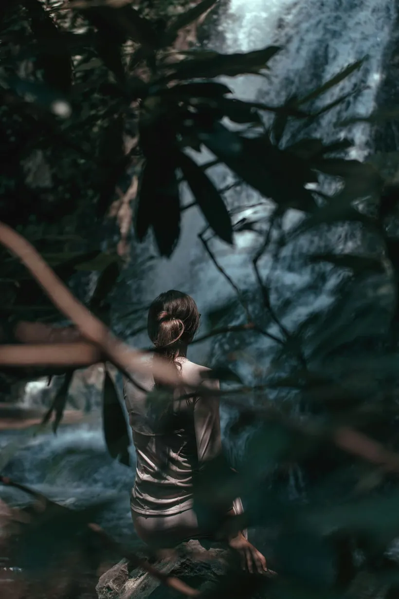 Frau am Wasserfall im Wald